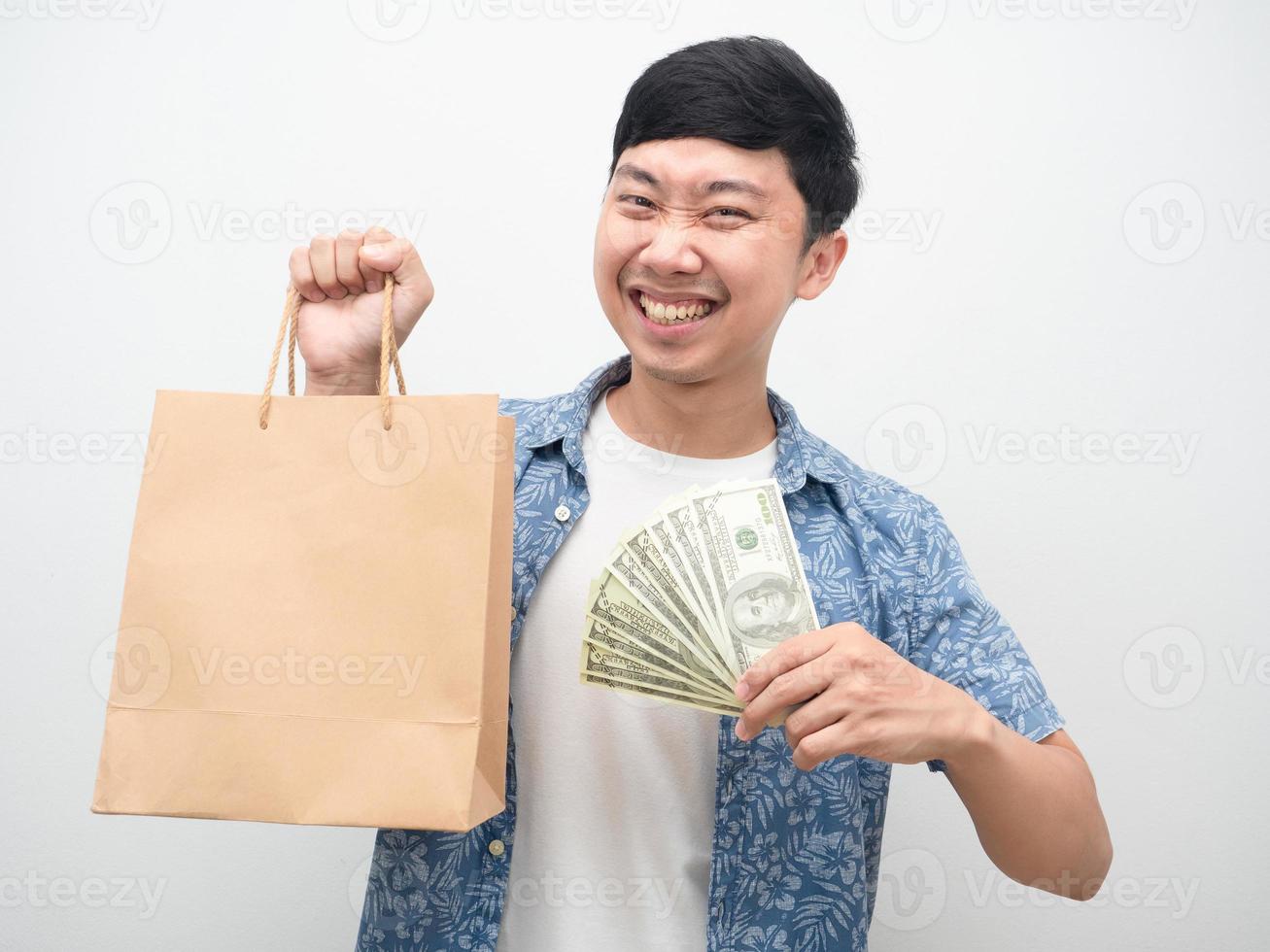 homem asiático felicidade com compras, homem alegre segurando muito dinheiro e sacola de compras foto