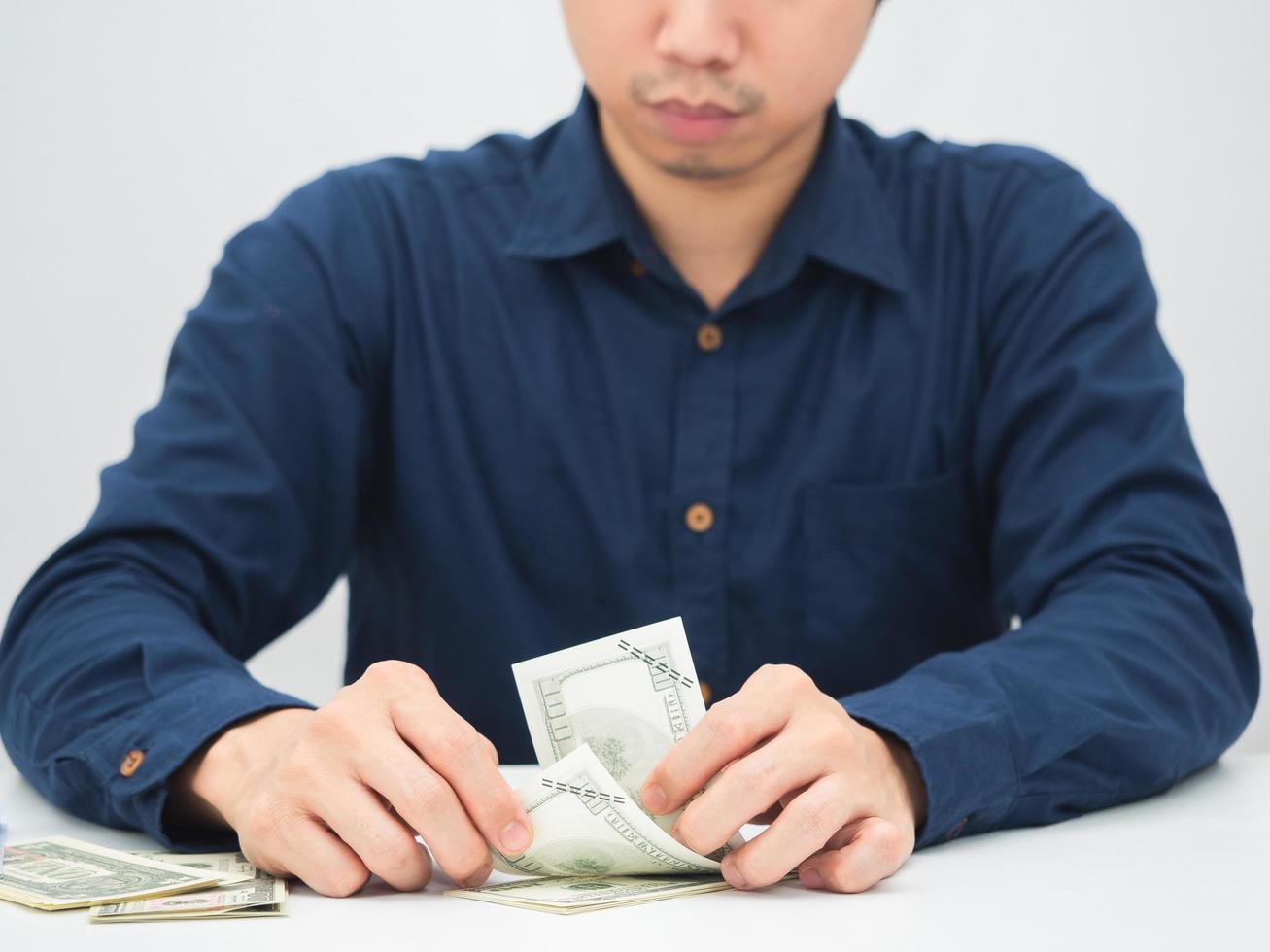 homem sentado na mesa e contando dinheiro na mão, empresário contando o conceito de dinheiro foto