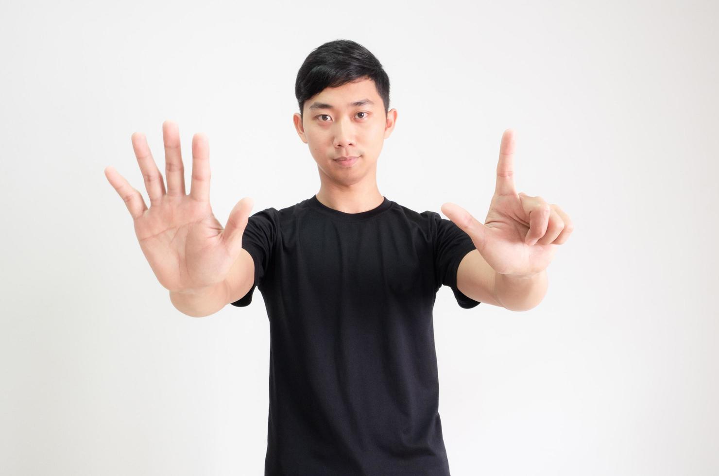 jovem asiático camisa preta contar de um a dez à mão meio corpo em fundo branco isolado, homem contando o conceito de número foto