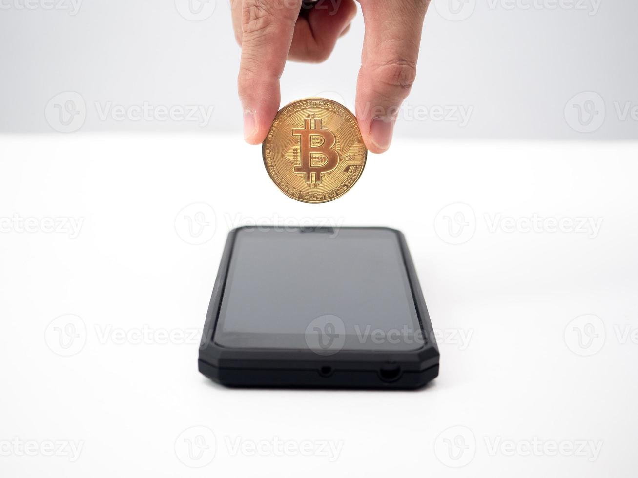fechar a mão pegar bitcoin fora do telefone inteligente, conceito de dinheiro digital foto