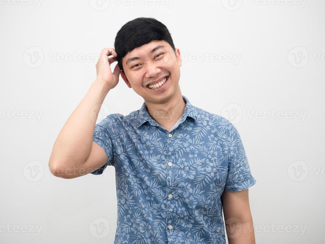 homem asiático feliz emoção sorriso gesto tímido toque em sua cabeça foto