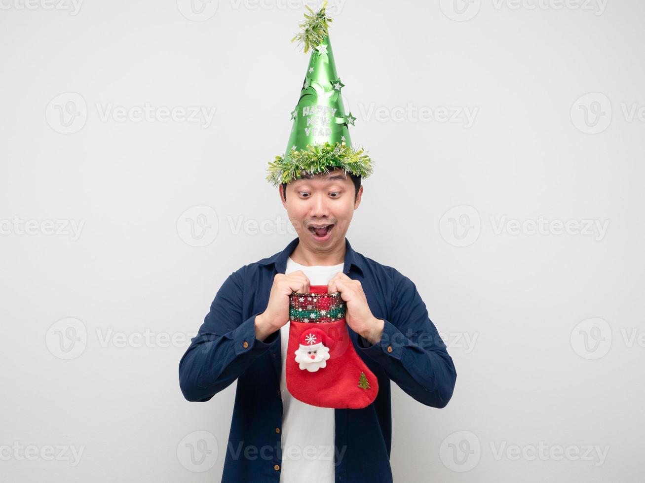 homem asiático olhando para a meia de natal na mão e sentindo-se espantado com o fundo branco foto