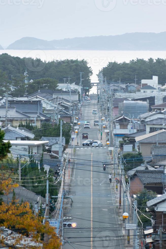 vista da estrada de rua local leva à beira-mar no subúrbio rural de fukuoka na hora do pôr do sol foto