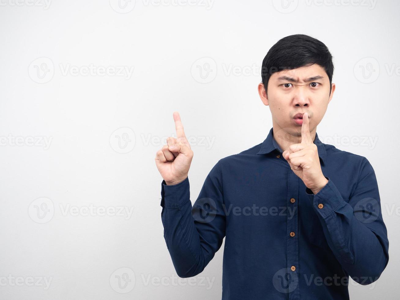 homem rosto sério gesto shh aponte o dedo para o espaço da cópia fundo branco foto