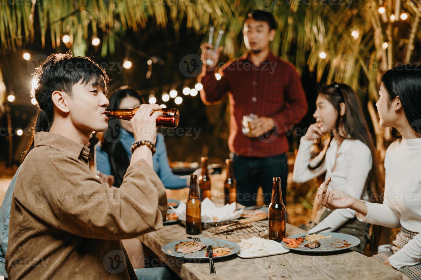 amigos felizes torcendo e bebendo cerveja em uma festa ao ar livre foto