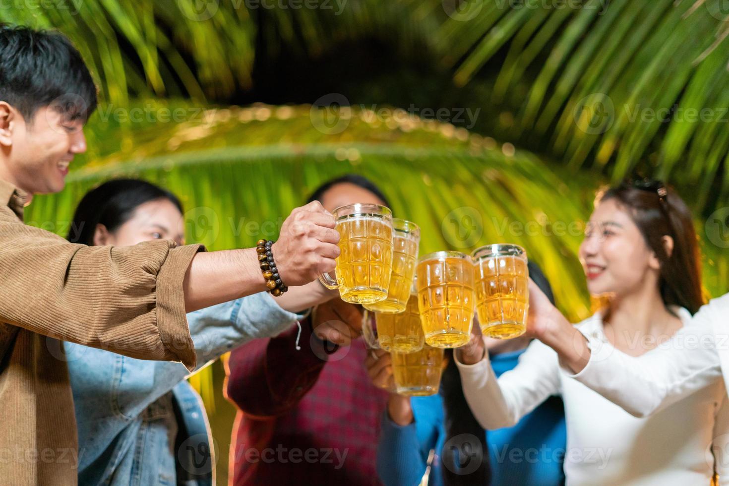 grupo de amigos alegremente brindando brindes de cervejas foto