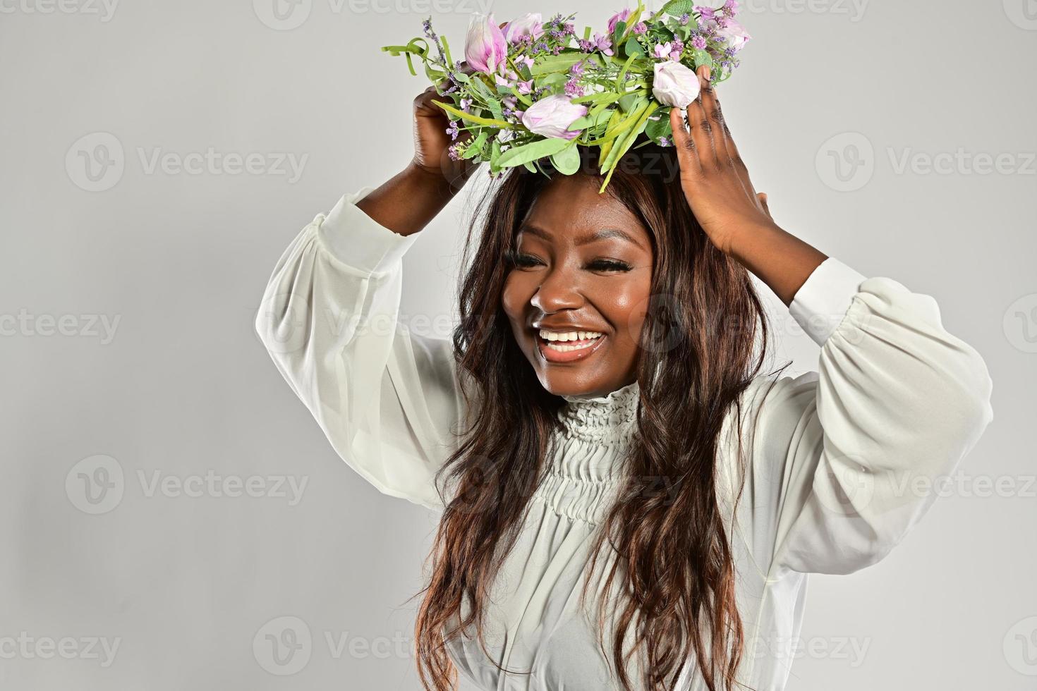 retrato de uma jovem mulher afro-americana, modelo de moda, com grandes flores no cabelo foto