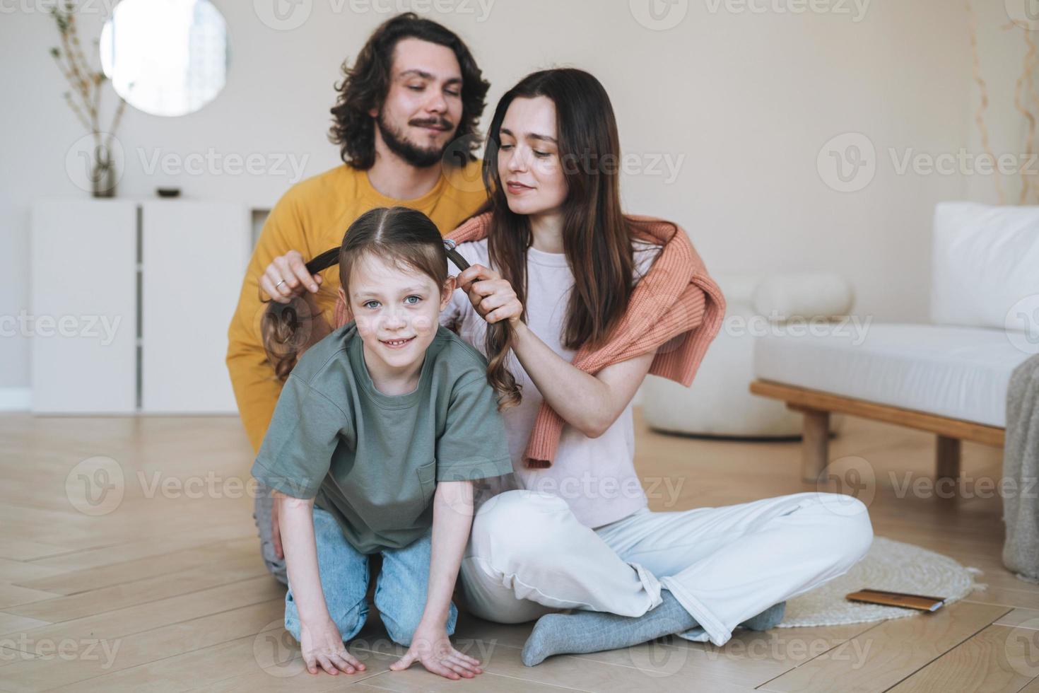 jovem família feliz com criança menina se divertindo na sala de estar em casa foto