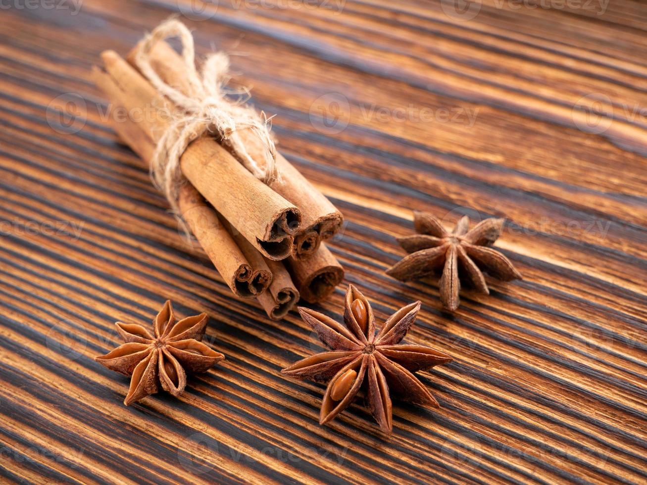 especiarias tradicionais de natal. anis estrelado, paus de canela amarrados com corda em fundo de madeira. nitidez selecionada foto