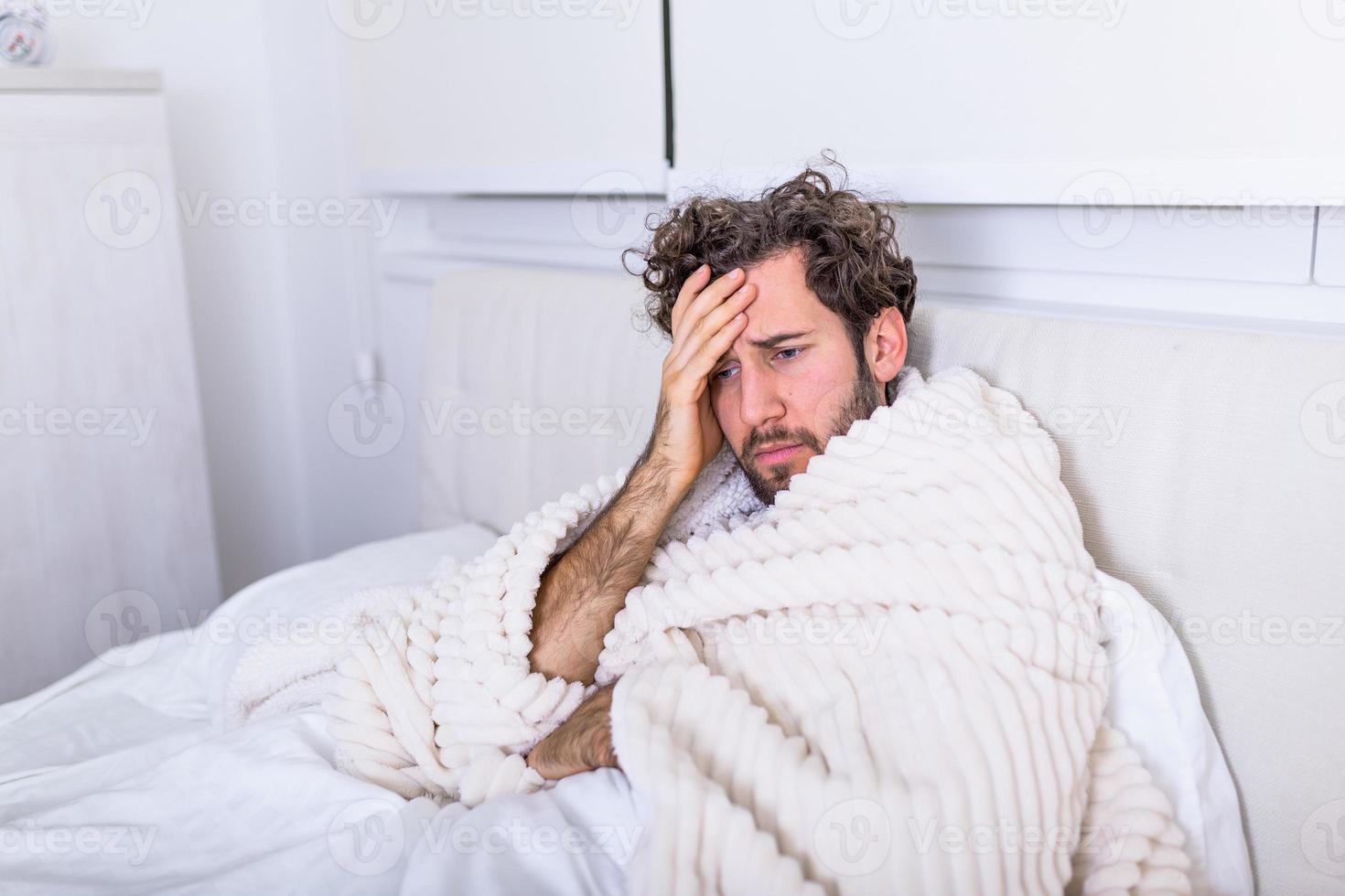 homem doente com infecções sazonais, gripe, alergia deitada na cama. homem bonito doente coberto com um cobertor deitado na cama com febre alta e gripe, descansando. foto