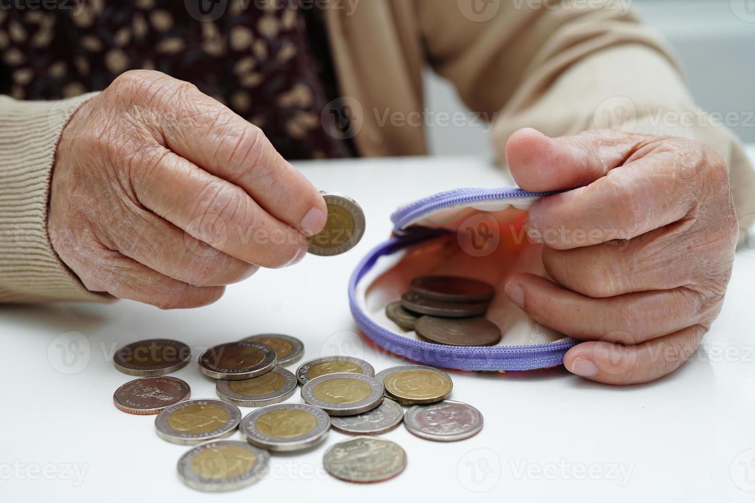 idosa aposentada contando dinheiro de moedas e se preocupa com despesas mensais e pagamento de taxa de tratamento. foto