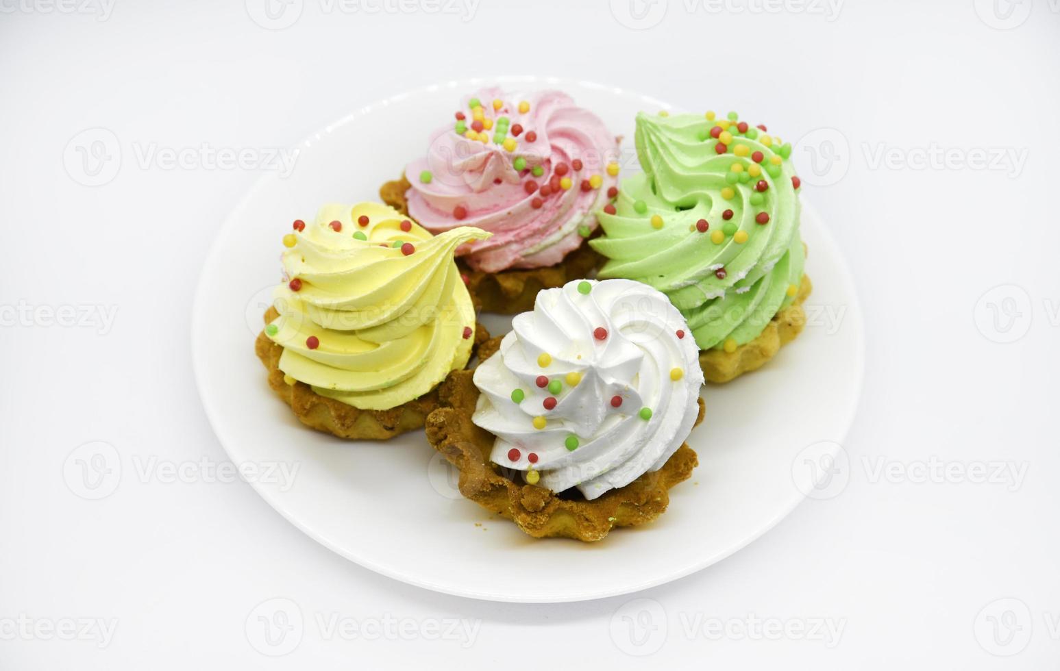 deliciosos bolos coloridos em um prato. bolos de creme em um fundo branco. bolos de shortbread. foto