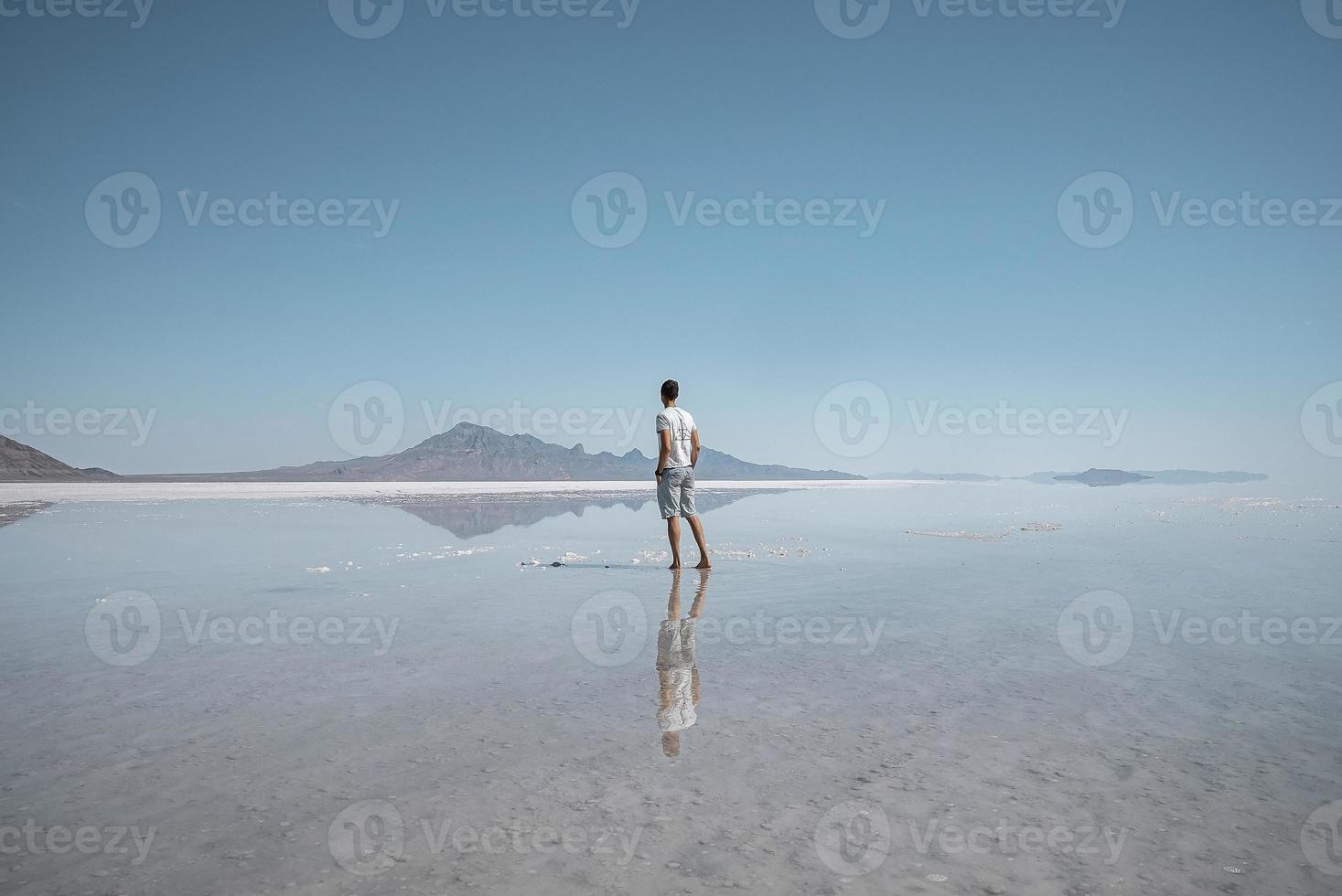 homem passeando pela planície de sal de bonneville e montanhas durante as férias de verão foto