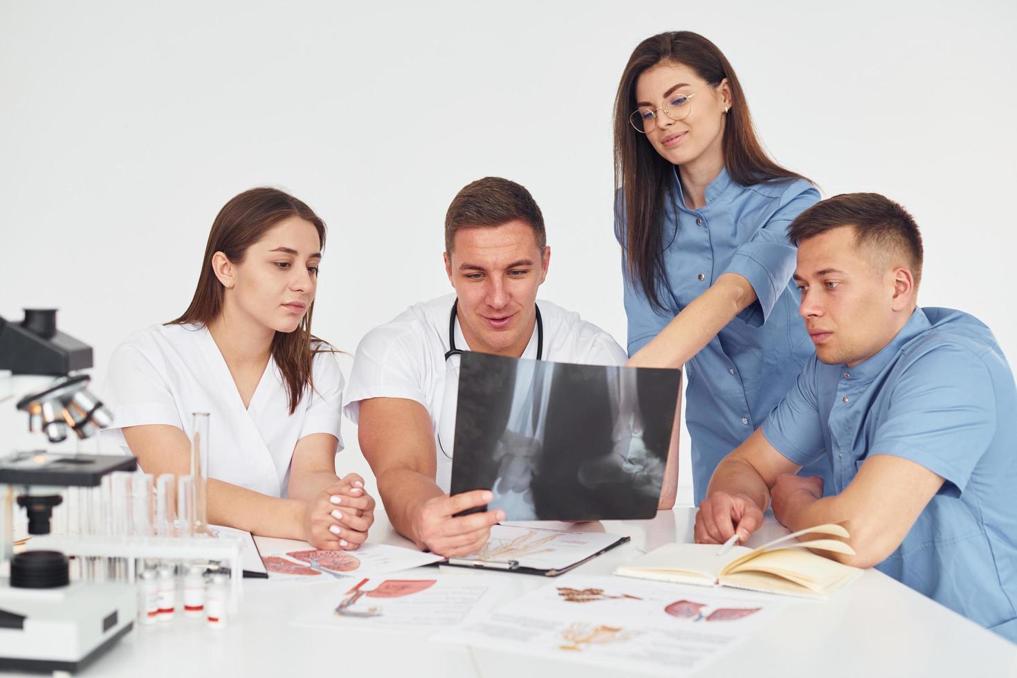 grupo de jovens médicos está trabalhando juntos no escritório moderno foto