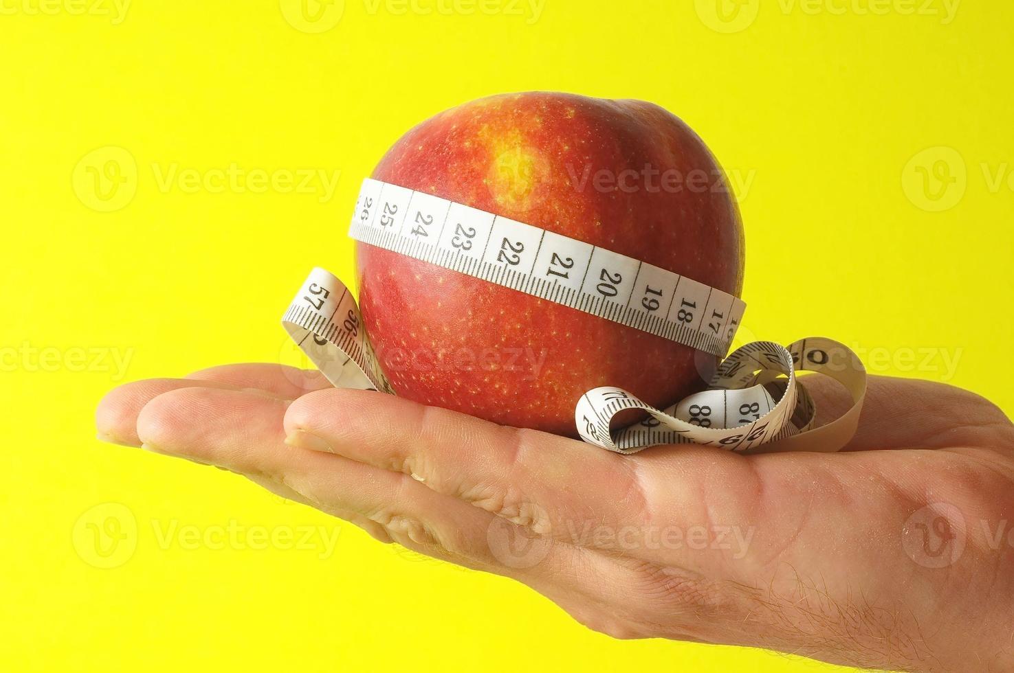 maçã de dieta e medidor na mão foto