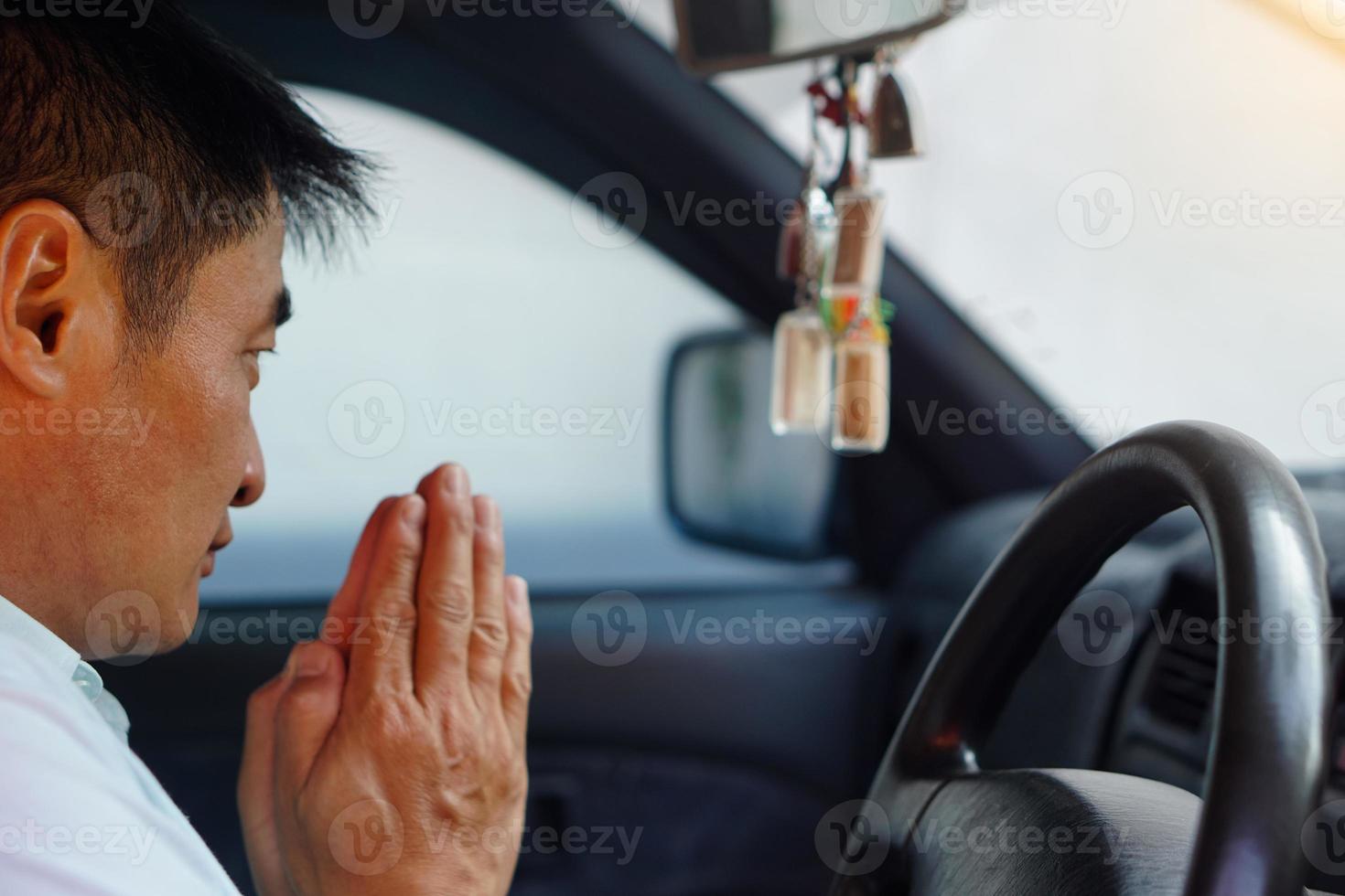 motorista asiático está rezando por uma direção segura e boa sorte com os amuletos de Buda tailandês em seu carro. conceito, fé e crença para budista para santo e sorte. prevenção de acidentes. foto