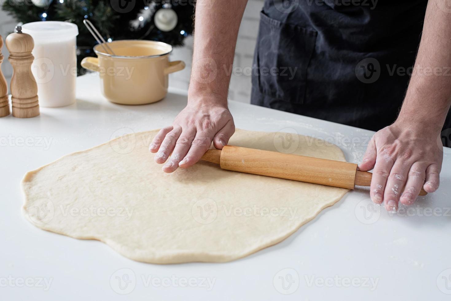 chef masculino trabalhando com massa, cozinhando rolos de canela foto