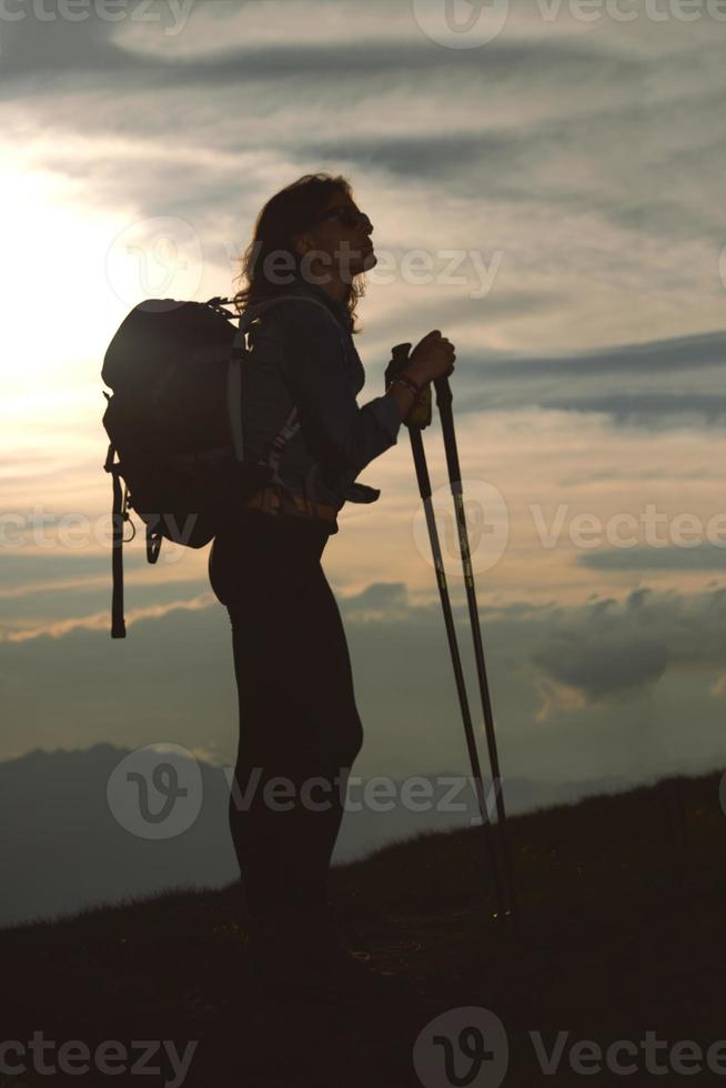 uma garota solitária com sua mochila descansa e observa o panorama durante uma peregrinação religiosa foto