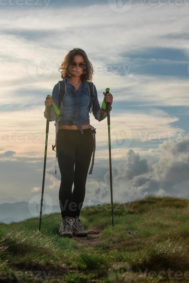 linda garota com pólos durante uma caminhada nas colinas foto