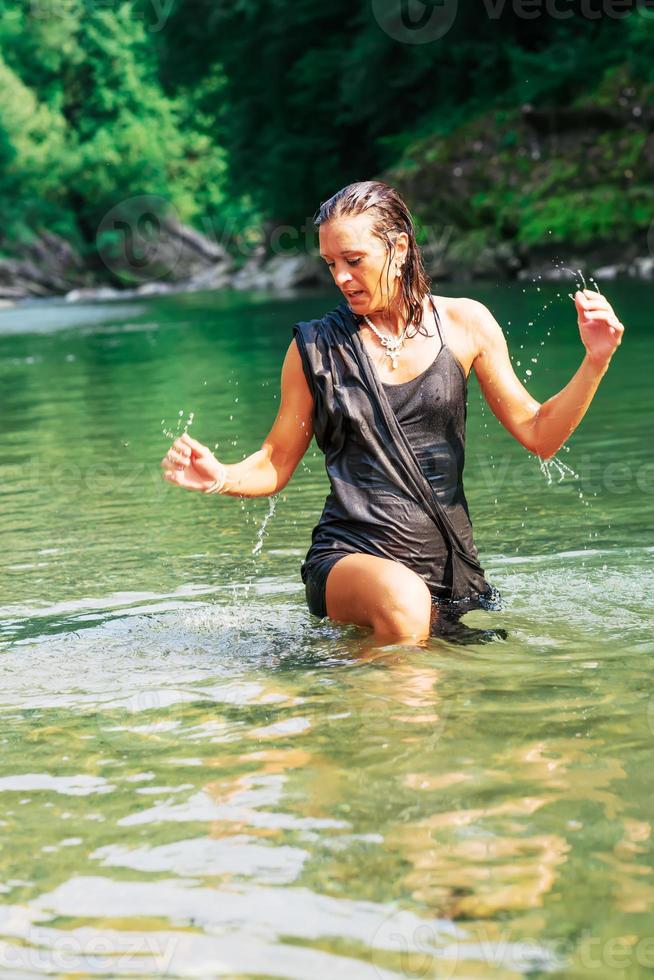 linda mulher de vestido preto em um rio foto