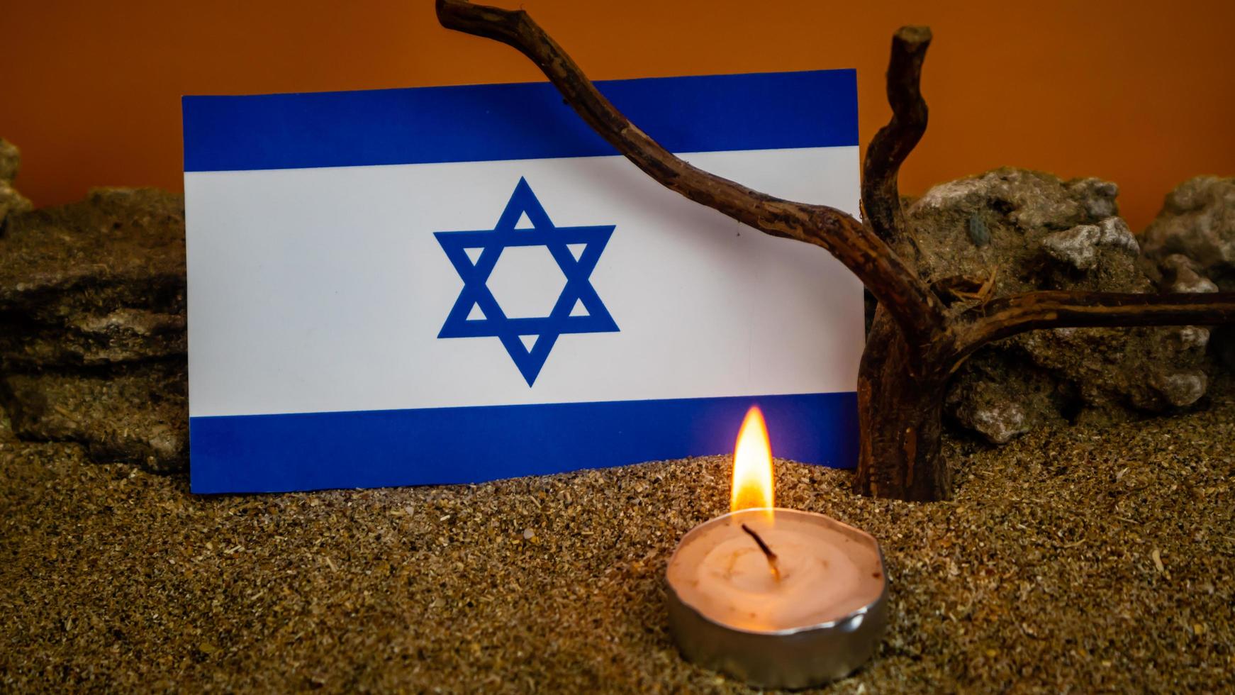 bandeira israelense e velas queimando na frente dela, dia da memória do holocausto foto