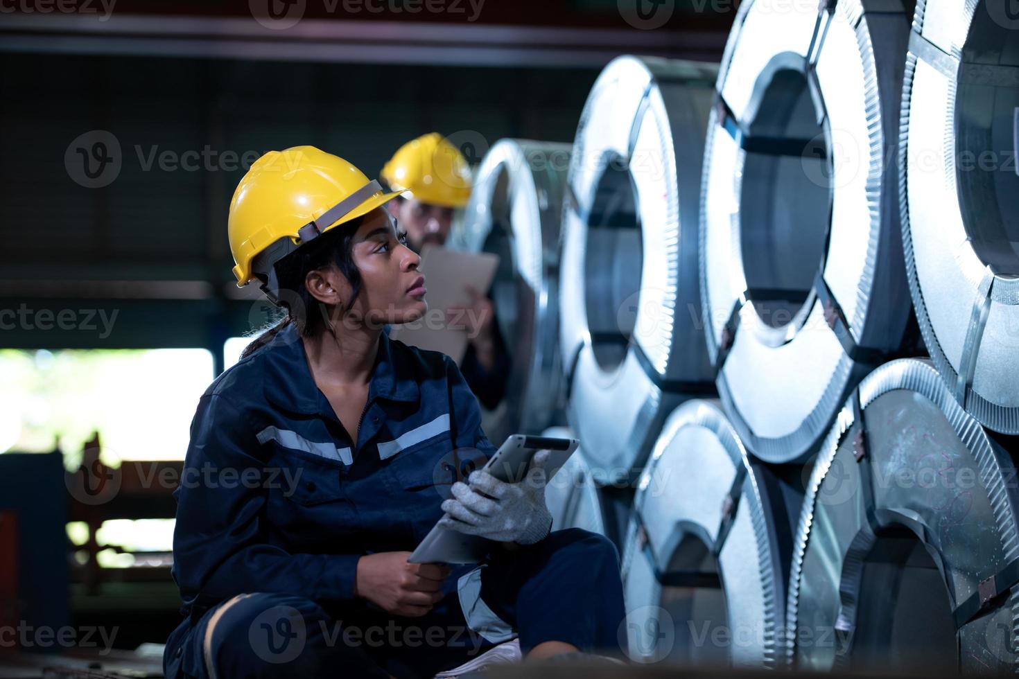 jovem engenheira aprendendo a operar máquinas em uma fábrica com engenheiros veteranos foto