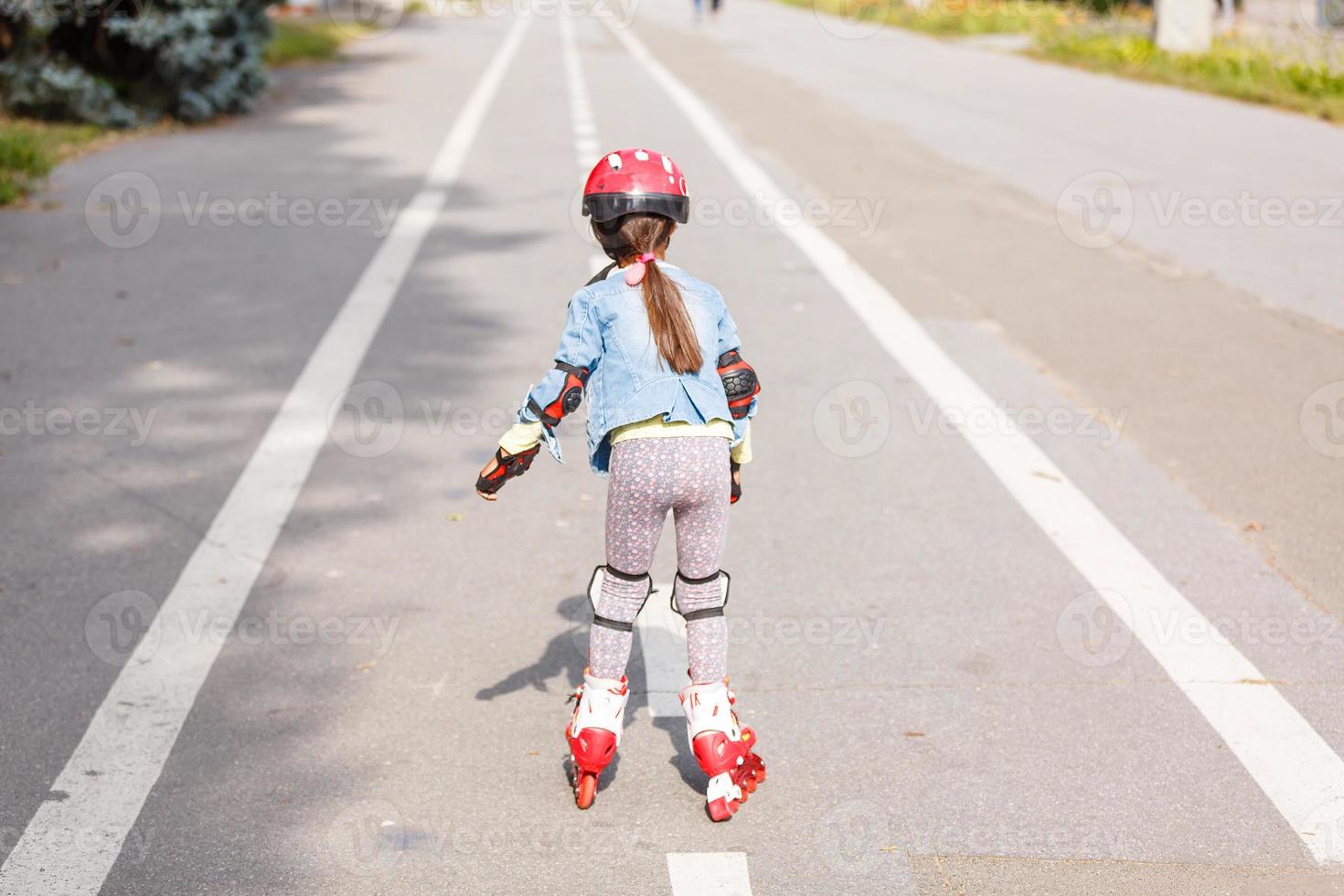 menina andando de patins ao longo dos trilhos foto