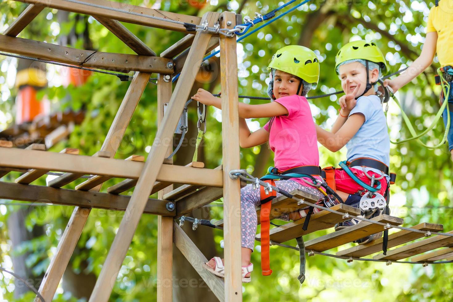 parque de escalada de aventura - parque de corda para crianças no curso de capacete de montanha e equipamento de segurança foto