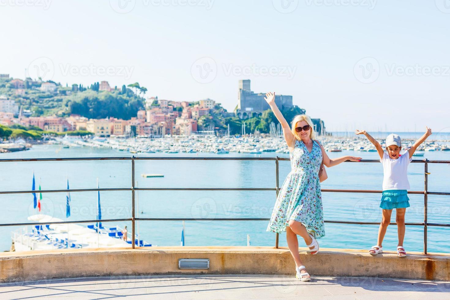 mãe e filha no lago garda com montanhas, lago e cidade ao fundo. o lago de garda é o maior lago da itália. estilo de vida, férias e conceito de viagem. foto