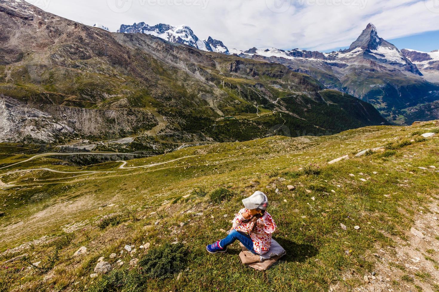 menina com uma mochila nos Alpes suíços com o famoso Monte Matterhorn no fundo. foto