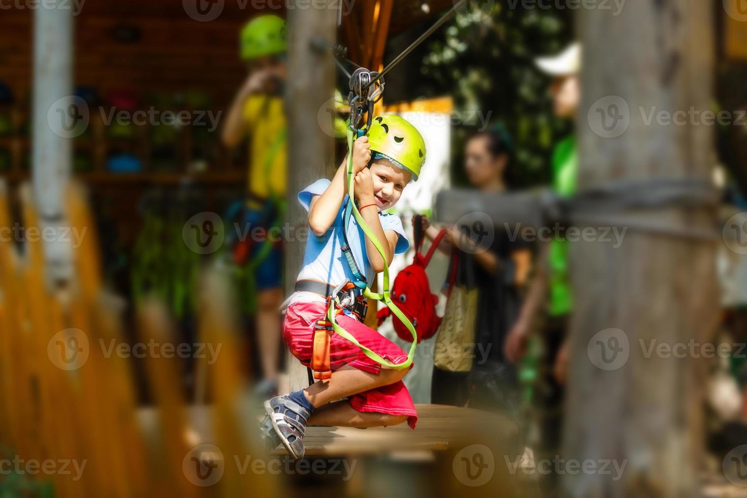 parque de escalada de aventura - parque de corda para crianças no curso de capacete de montanha e equipamento de segurança foto