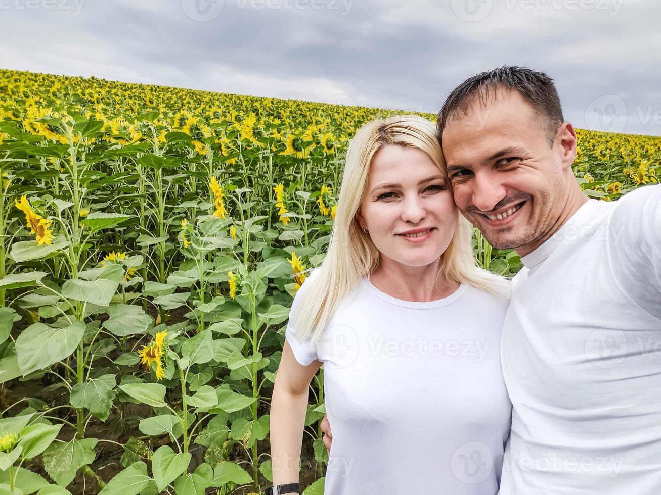 natureza de outono. jovem casal romântico caminhando no campo de girassol no pôr do sol foto