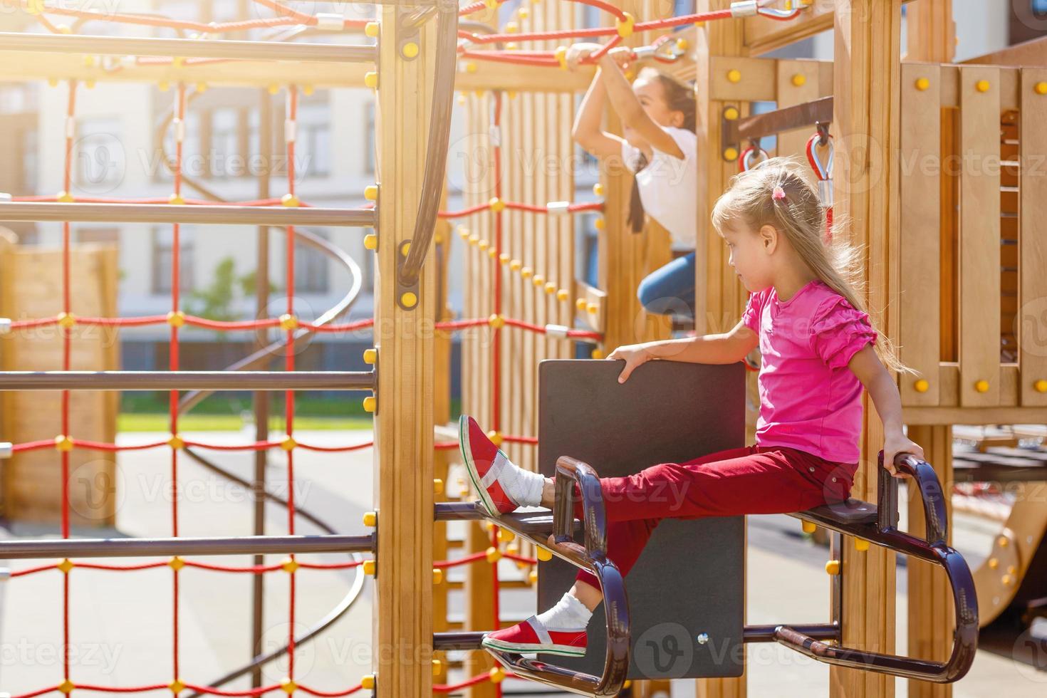 menina atraente em equipamentos de playground ao ar livre foto