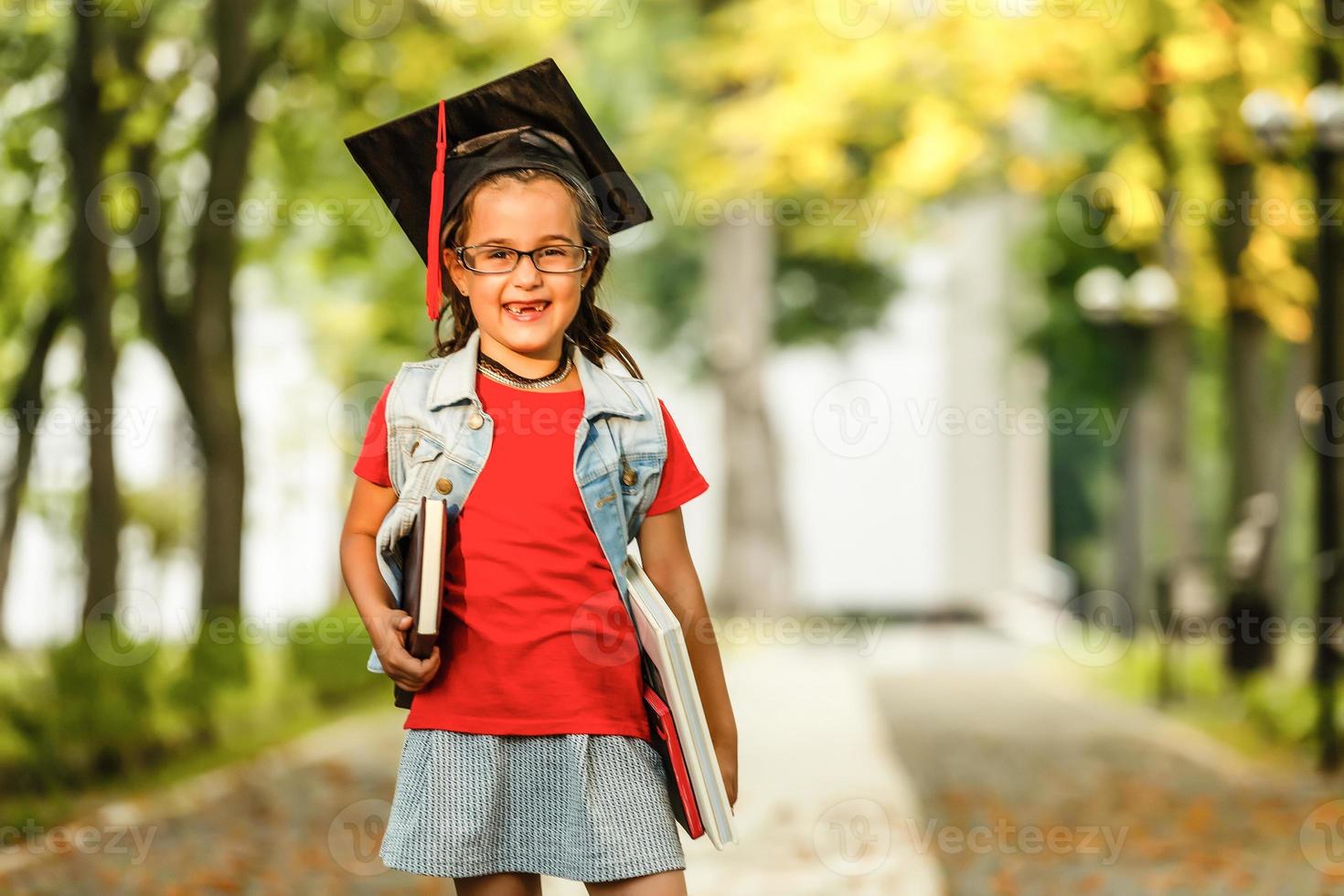 tiro autêntico de menina bonita e elegante com chapéu de formatura está sorrindo durante a cerimônia. foto