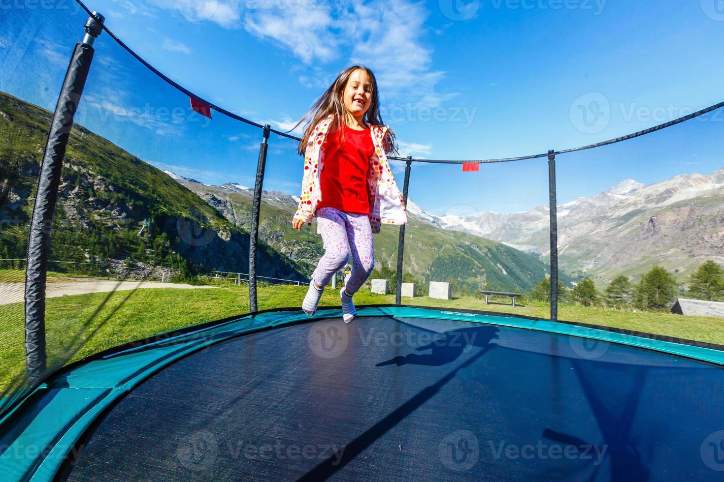 menina engraçada e feliz no topo da montanha. crianças ao ar livre. inspiração foto