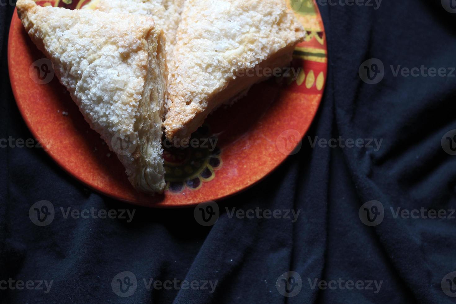 pastéis de maçã, torta de maçã, servidos em um prato laranja em um fundo de pano preto, pastéis de maçã é um prato popular na América - flat-lay. foto