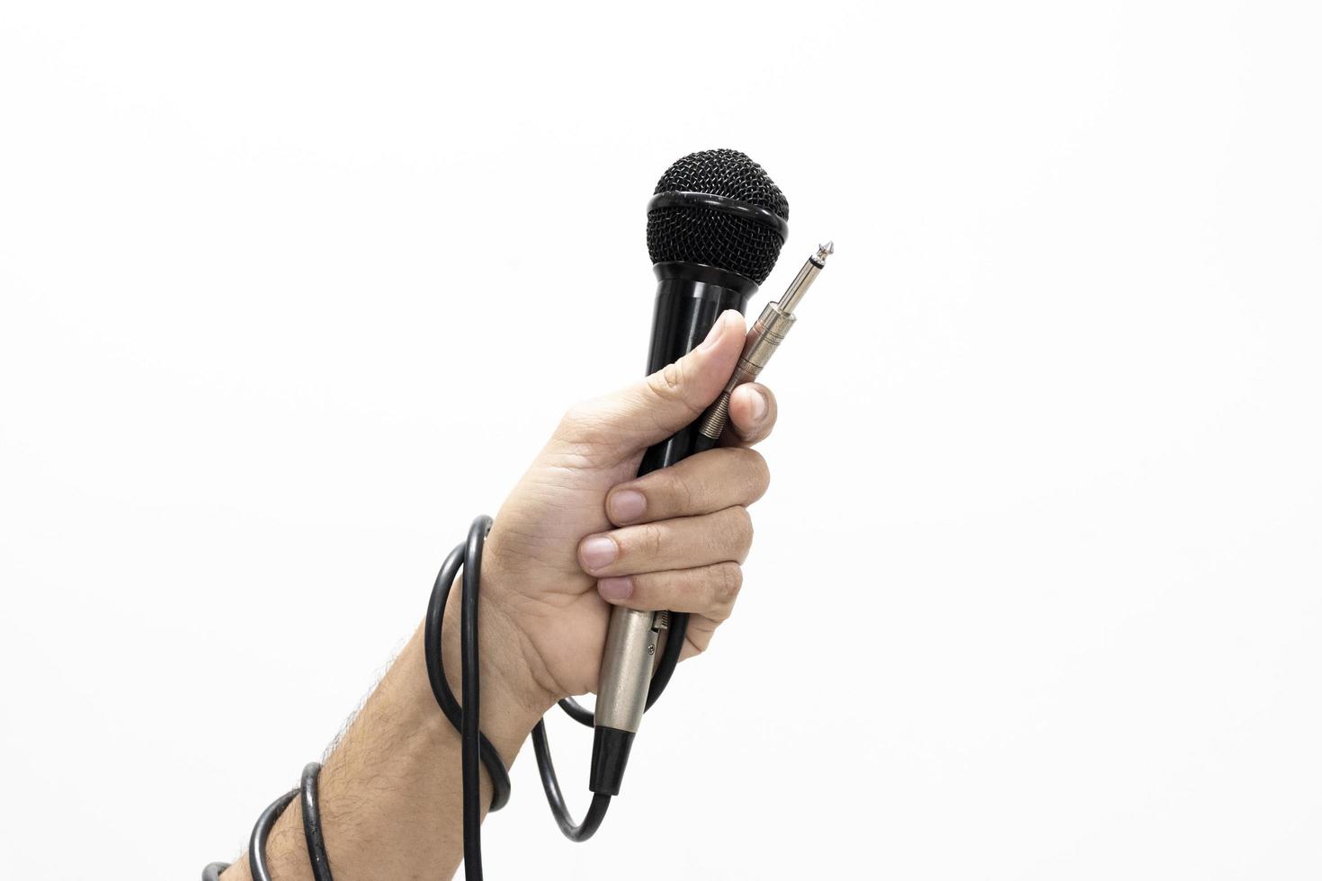 mão segurando um microfone isolado no fundo branco foto