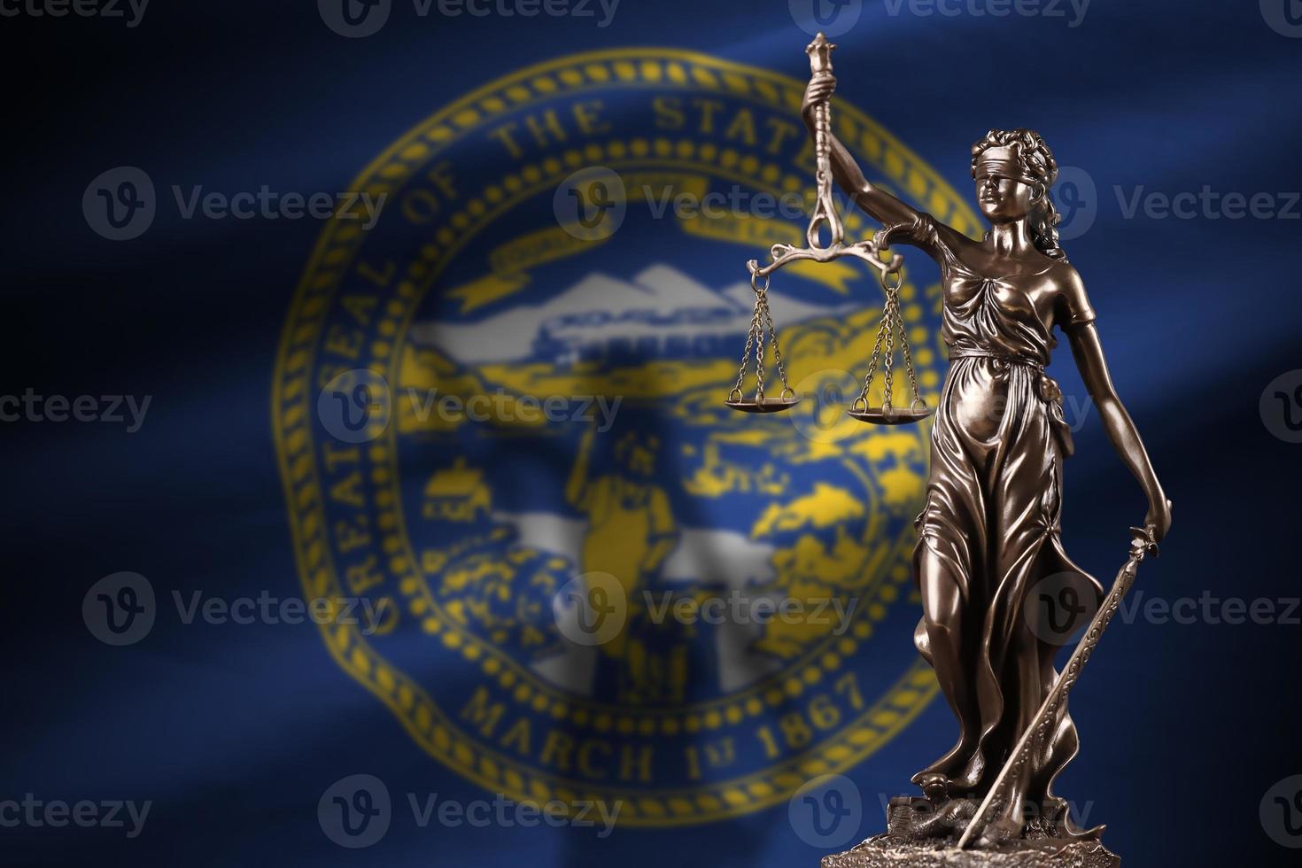 bandeira do estado de nebraska eua com a estátua da justiça e balança judicial em quarto escuro. conceito de julgamento e punição foto