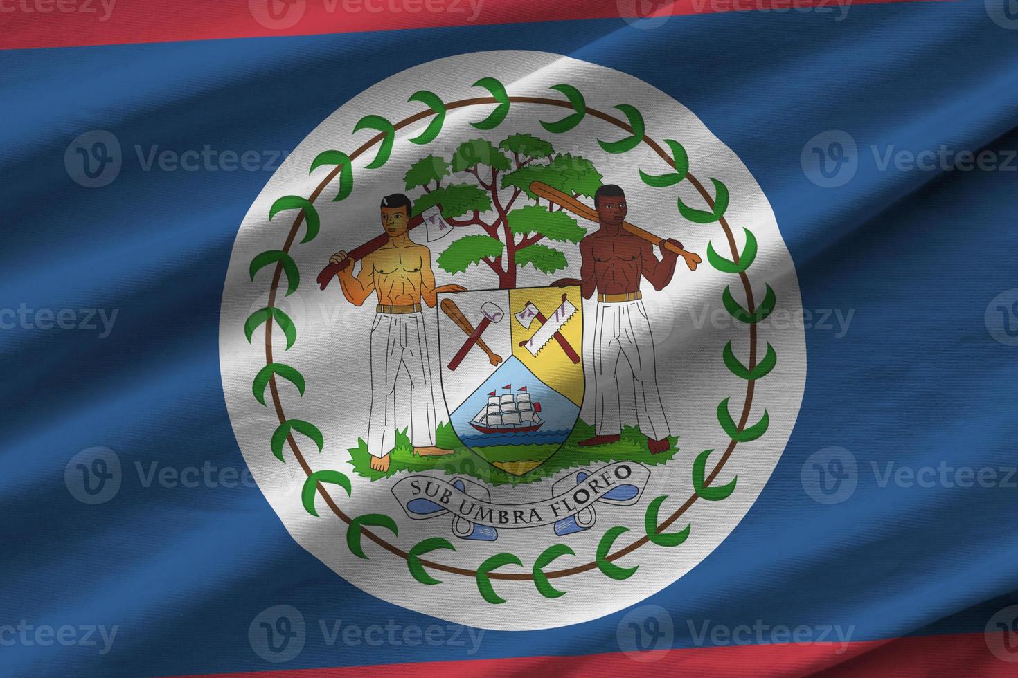 bandeira de belize com grandes dobras acenando perto sob a luz do estúdio dentro de casa. os símbolos e cores oficiais no banner foto