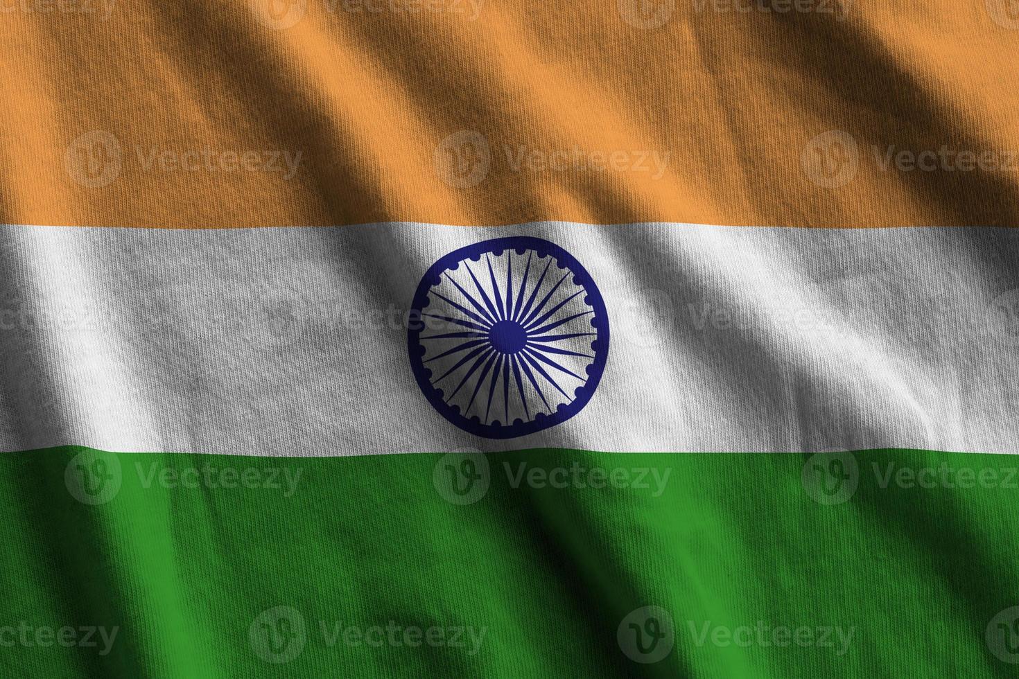 bandeira da índia com grandes dobras acenando perto sob a luz do estúdio dentro de casa. os símbolos e cores oficiais no banner foto