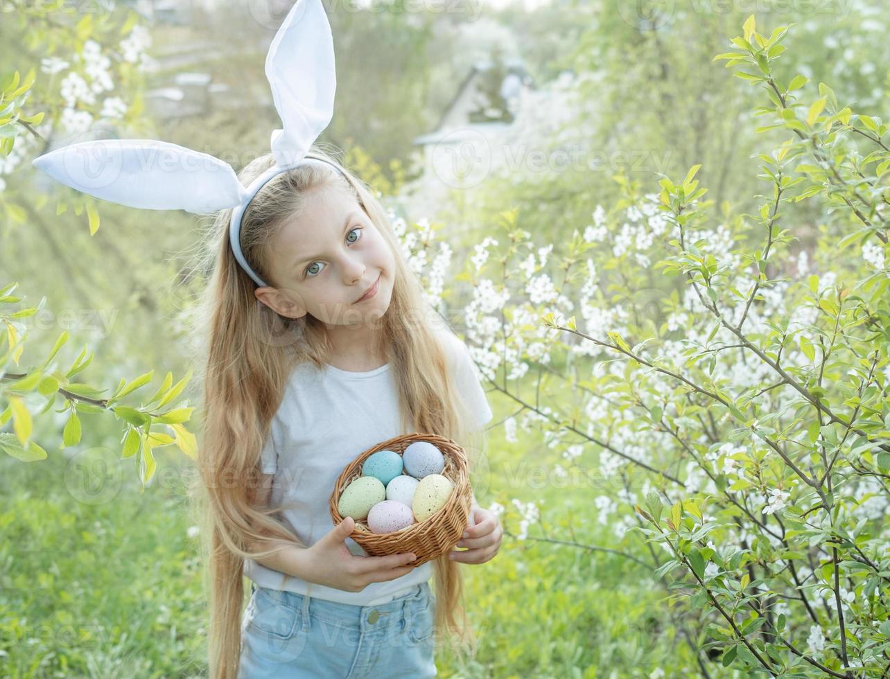 criança bonitinha usando orelhas de coelho no dia de páscoa foto