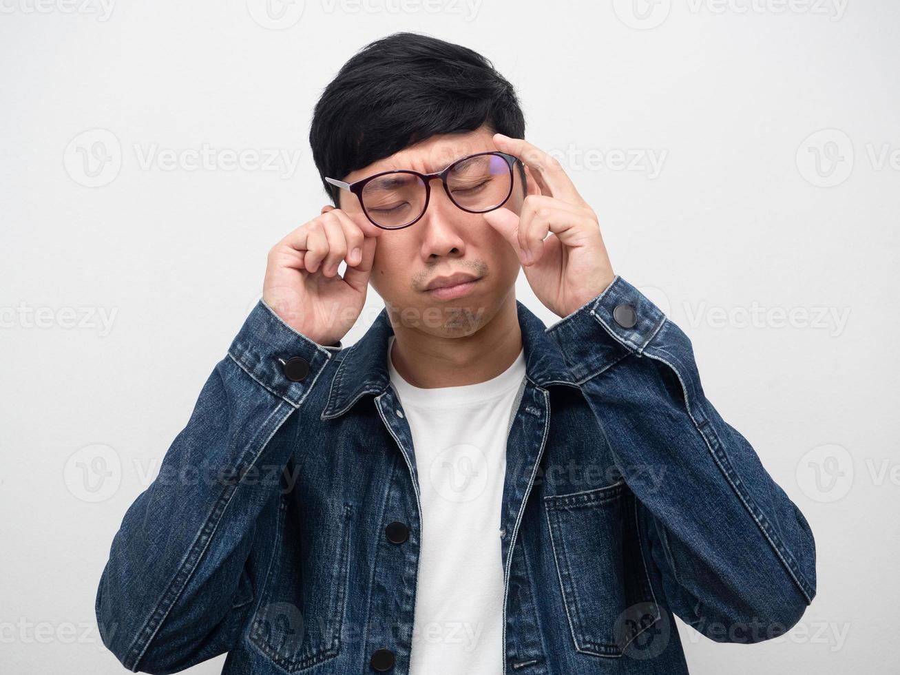 homem vestindo camisa de jeans de óculos sente tristeza e choro tiro do estúdio foto