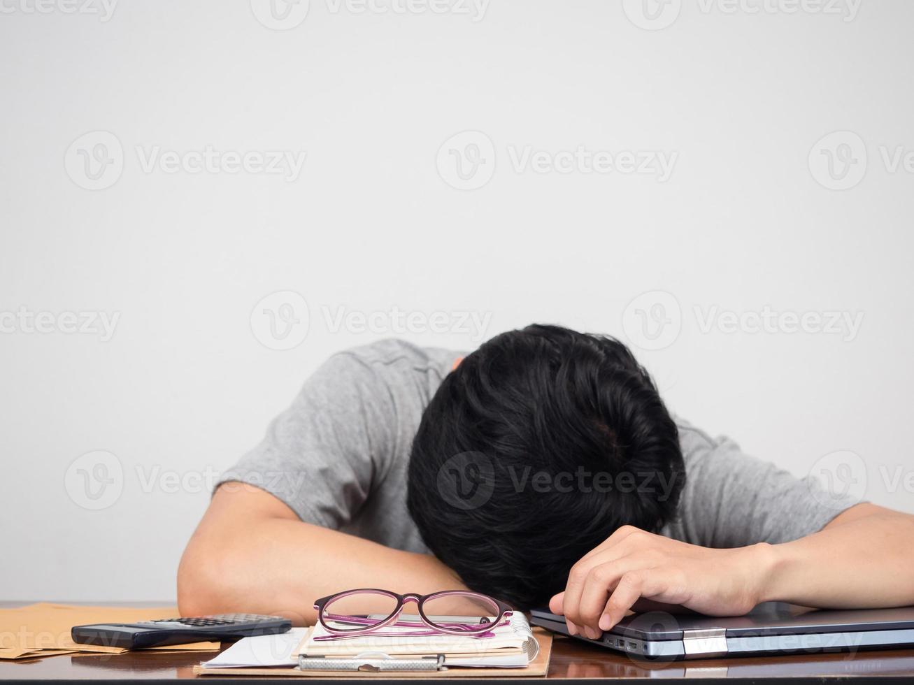 homem deitado de cabeça na mesa de trabalho tentou trabalhar foto