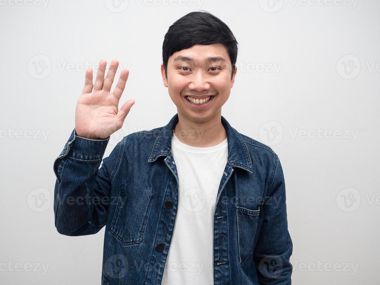 homem positivo camisa jeans mostra mão para cima olá isolado foto