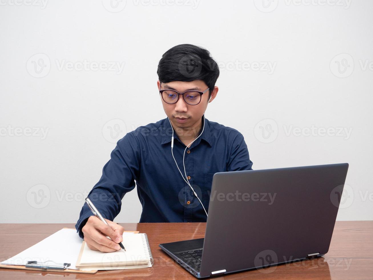 homem de óculos trabalhando em seu espaço de trabalho, homem escrevendo no notebook trabalhando fundo branco foto