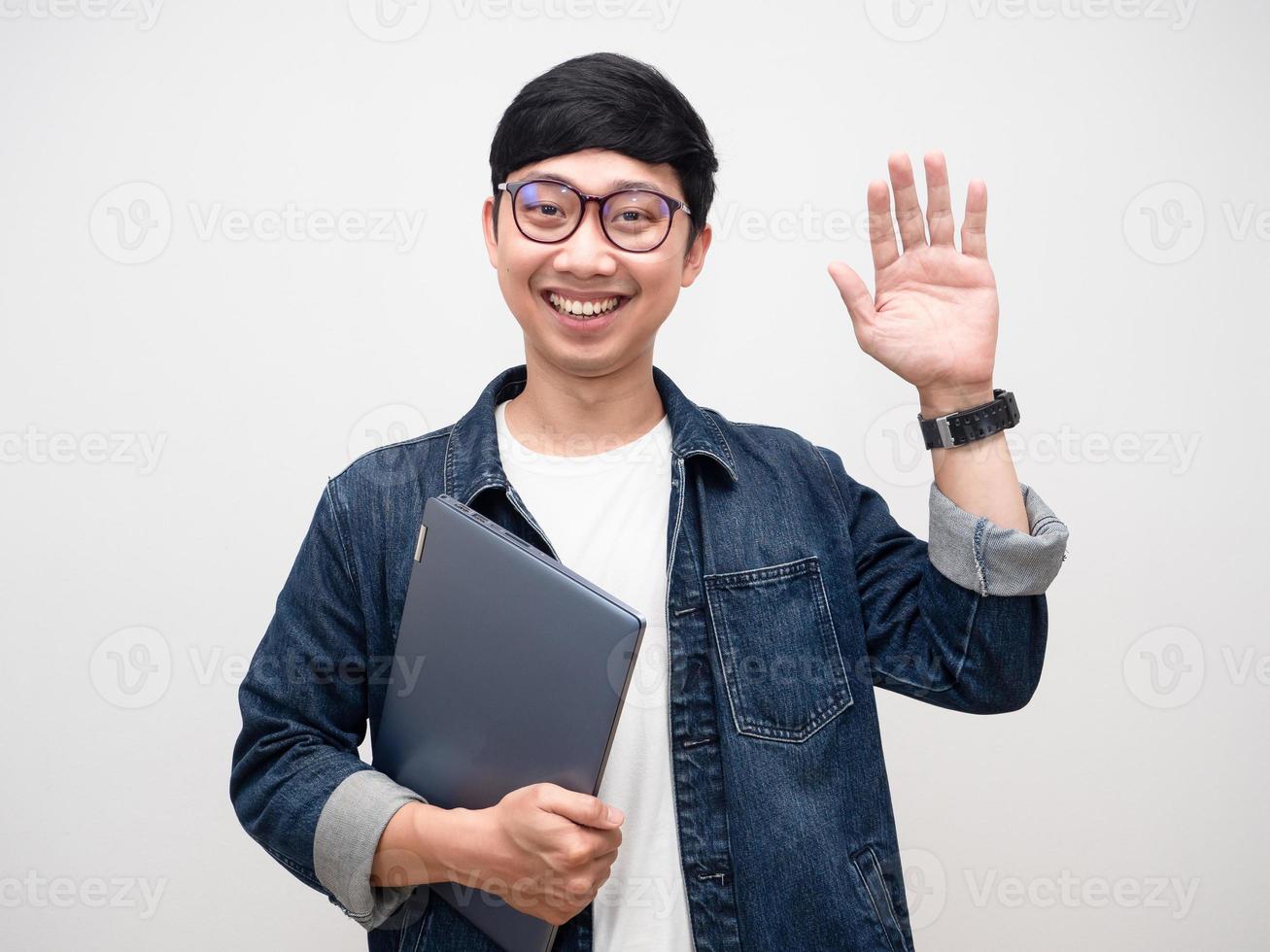 jovem de óculos segurando laptop sorriso gentil gesto cumprimentar isolado foto