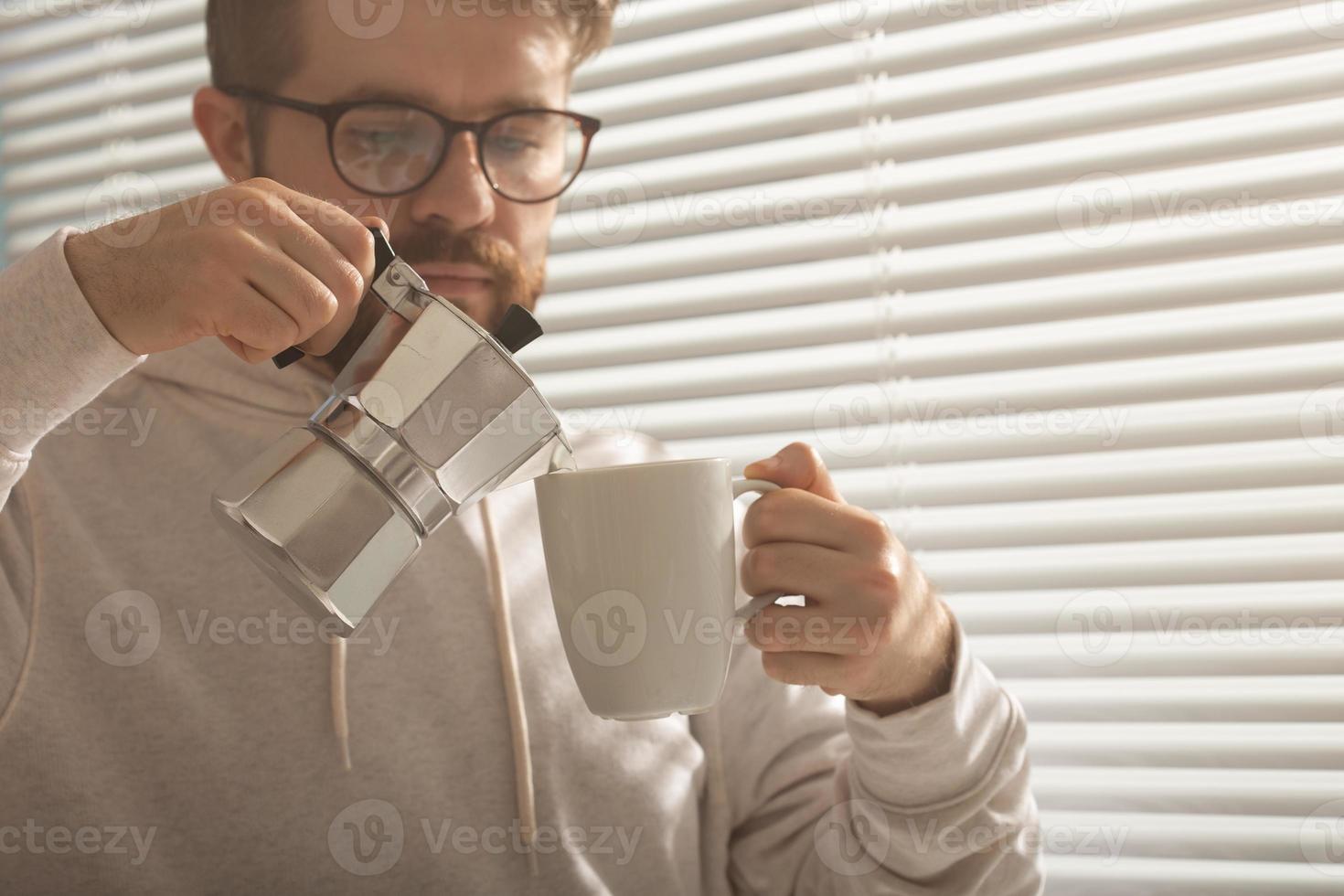 retrato do close-up do jovem elegante homem moderno servindo café no escritório num dia de verão. conceito de manhã revigorante e humor positivo foto