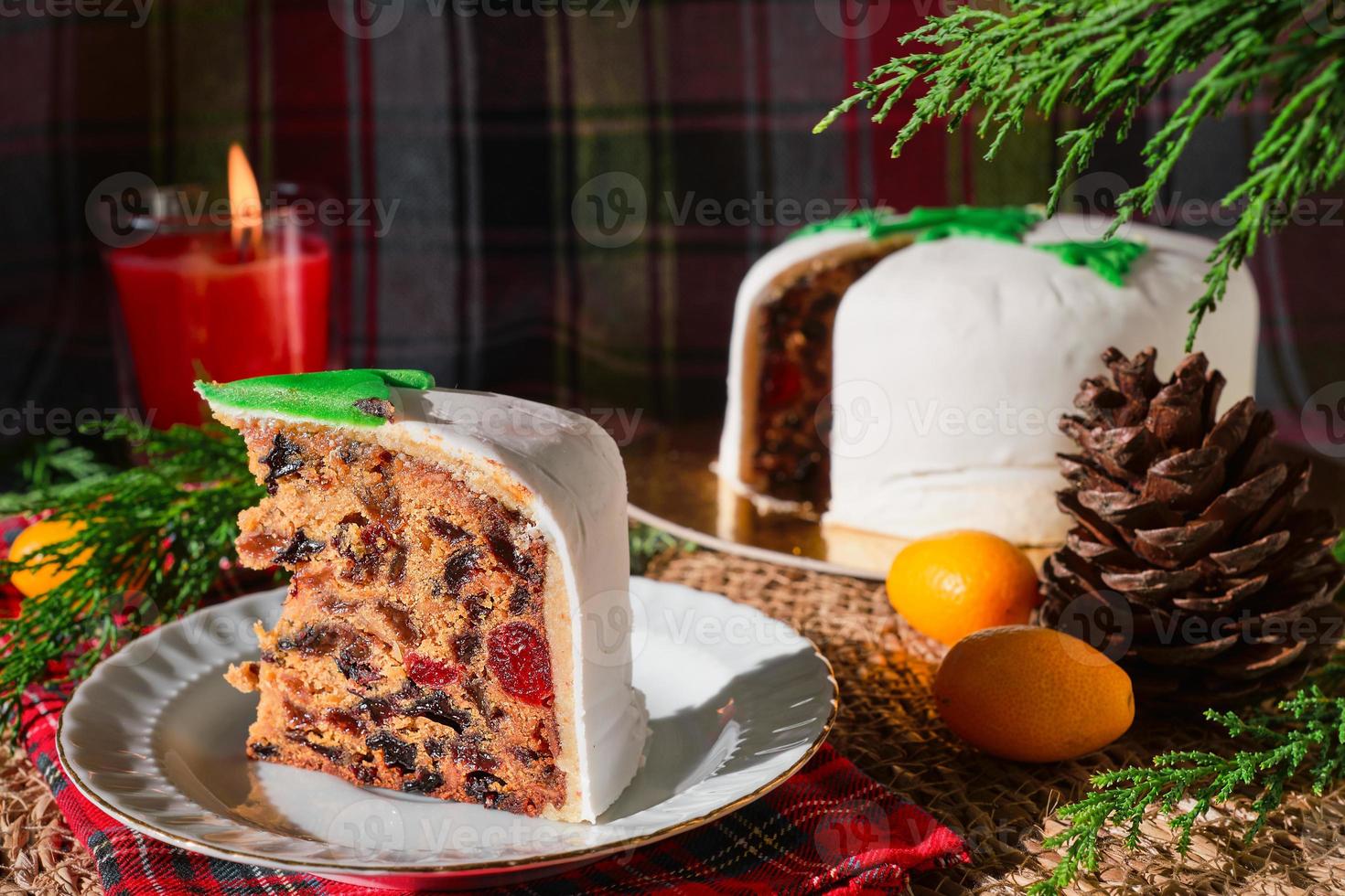 close-up em uma fatia de um bolo inglês tradicional de natal, no contexto de decorações de natal. natureza morta de comida de natal com um cupcake inglês frutado decorado com neve de maçapão. foto