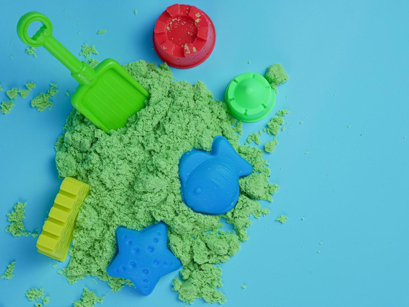 conjunto de brinquedos de areia verde e estampas isoladas em fundo azul foto