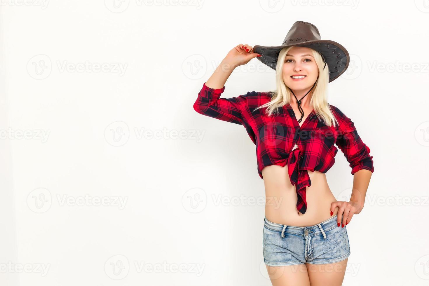 a mulher loira sexy com um chapéu de cowboy em um fundo branco foto